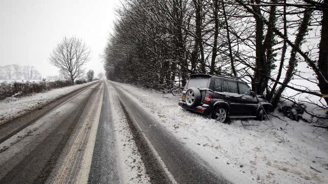 A photo of an SUV crashed on a snowy road. 