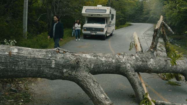 A tree blocks the road for an RV.