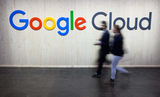 Les visiteurs du salon passent devant un logo Google sur le stand Google à la Messe de Hanovre 2024. 