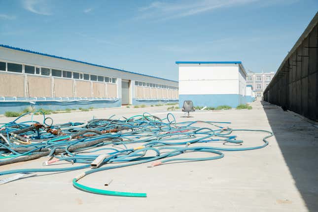 Leftover tubing and cables lying on the ground between two mining units.