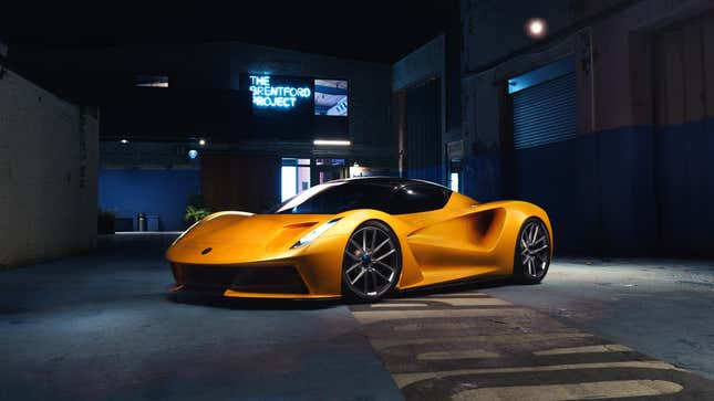 A yellow Lotus Evija sitting in a dimly-lit gallery