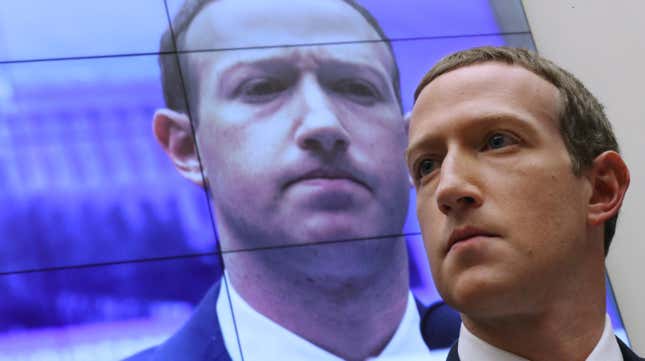 With an image of himself on a screen in the background, Facebook co-founder and CEO Mark Zuckerberg testifies before the House Financial Services Committee in the Rayburn House Office Building on Capitol Hill October 23, 2019