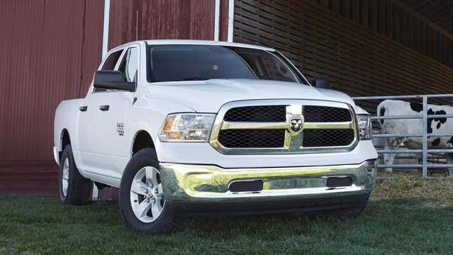 A white 2023 Ram 1500 Classic parked in front of a red barn