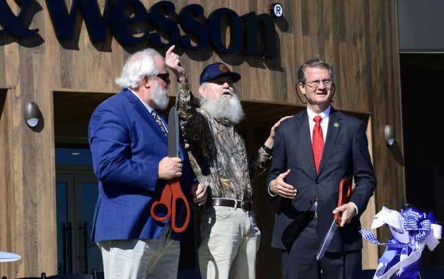 Blount County Mayor Ed Mitchell, from left, Si Robertson of &quot;Duck Dynasty&quot; and U.S. Representative Tim Burchett, R-Tenn, hold their ceremonial scissors Saturday, Oct. 7, 2023, after helping cut the ribbon to officially open the new Smith &amp; Wesson facility in Maryville, Tenn. The company moved its home to Tennessee from Massachusetts. (Scott Keller/The Daily Times via AP)