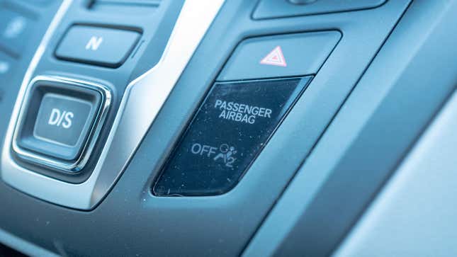 Close-up of passenger airbag indicator light on dashboard of a car.