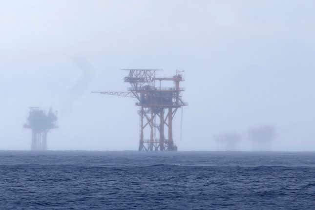 CORRECTS TO 382 MILLION NOT 328 FILE - Oil platforms are visible through the haze near the Flower Garden Banks National Marine Sanctuary in the Gulf of Mexico, off the coast of Galveston, Texas, Sept. 16, 2023. Oil companies offered $382 million for drilling leases in the Gulf Wednesday after courts rejected the Biden administration&#39;s plans to scale back the sale to protect an endangered whale species. (AP Photo/LM Otero, file)