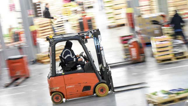 A fork lift truck driving through a warehouse 