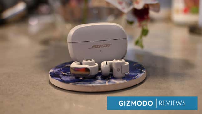 Bose Ultra Open earbuds on display on a coaster. 