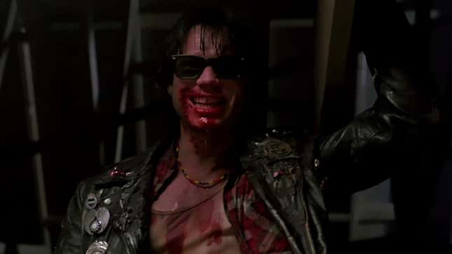 Bill Paxton grins with blood all over his face.