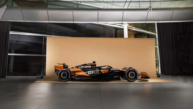 A side photo of the black and orange McLaren F1 car. 