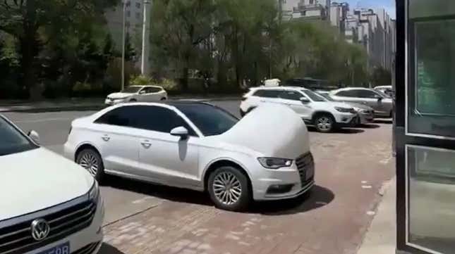 A photo from a tiktok carousel of a white Audi A3 with a giant bulge in the hood