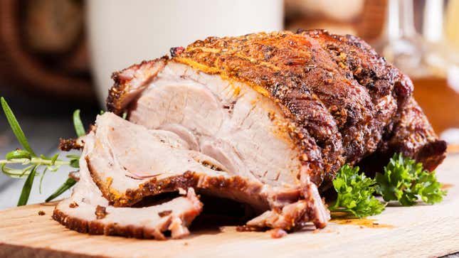 Roast pork shoulder on a cutting board.