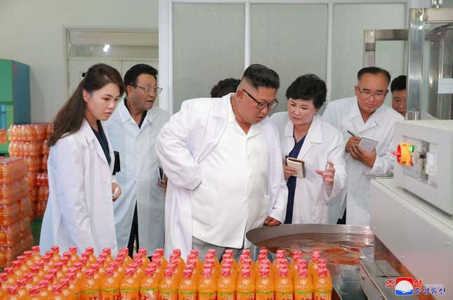 Kim Jong Un and his wife, Ri Sol Ju, (left) visit the Songdowon General Foodstuff Factory.