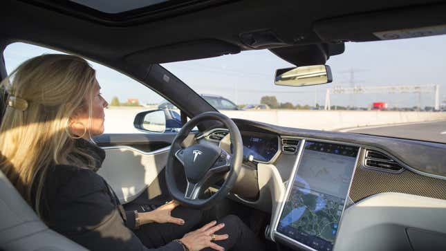 A photo of a person with their hands off the wheel of a Tesla car. 