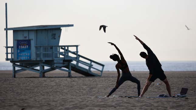 A photo of people doing yoga on the beach in California. 