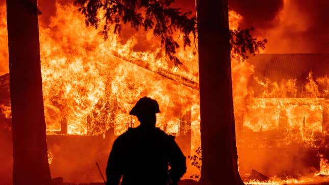 Firefighters attempt to get control of the scene as dozens of homes burn during the Dixie in the Indian Falls neighborhood of unincorporated Plumas County, California on July 24, 2021. 