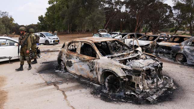 Israeli soldiers inspect burnt cars that are abandoned in a carpark near where a festival was held before an attack by Hamas gunmen from Gaza that left at least 260 people dead, by Israel's border with Gaza in southern Israel, October 10, 2023