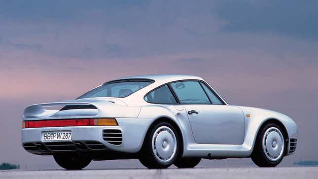 A side photo of a silver Porsche 959 supercar. 