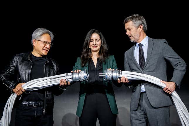 (L-R) Jensen Huang, Nadia Carlsten, and King Frederik X putting together two large power cords