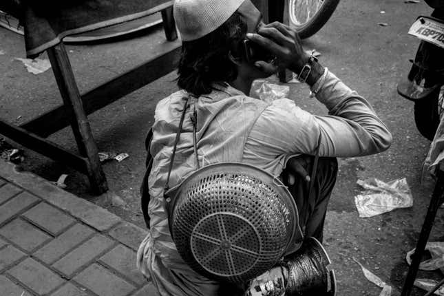A street-food vendor pauses for a phone call.