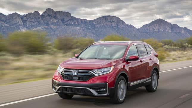 A red CRV hybrid driving in front of mountains