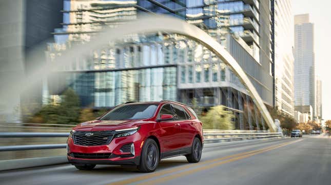 Une Chevrolet Equinox rouge traversant un pont près de gratte-ciel