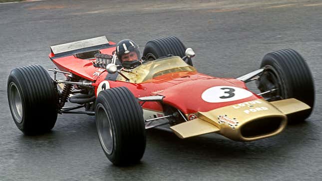 A photo of a red and gold Lotus Ford Formula 1 car. 