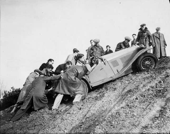 12th January 1936: Group of men helping a competitor get up a steep hill. Great West Motor Club's Haward Tanker Trial at Camberley Heath, Surrey, England