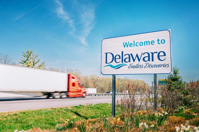 Semi-truck passes the “Welcome to Delaware” sign along U.S. Interstate 95.