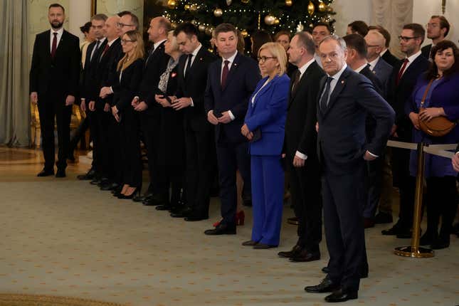 Poland&#39;s new Prime Minister Donald Tusk, right, stands next to ministers before the swearing-in ceremony at the presidential palace in Warsaw, Poland, Wednesday, Dec. 13, 2023. Donald Tusk was sworn in by the president in a ceremony where each of his ministers was also taking the oath of office. (AP Photo/Czarek Sokolowski)