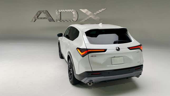 A photo of the rear of the white ADX in a white photo studio in front of a metal ADX sign