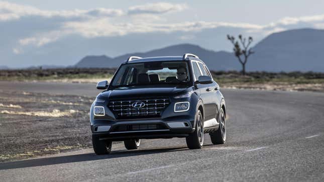 A gray Hyundai Venue driving on a deserted road