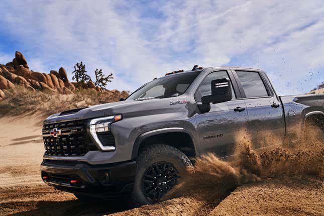 A grey 2024 Chevy Silverado HD driving quickly in the sand