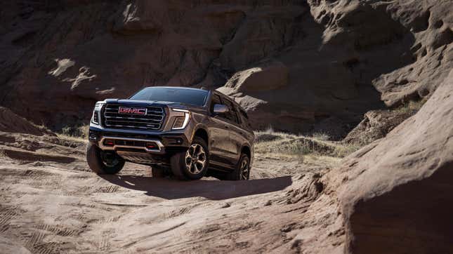 A GMC Yukon AT4 driving up a rock