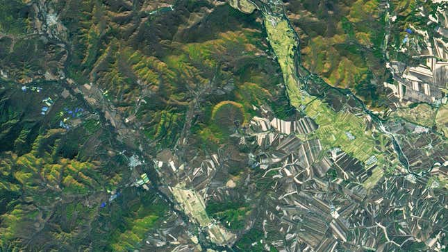 A green crescent at center is the Yilan Crater from above, surrounded by wildnerness and agricultural fields.
