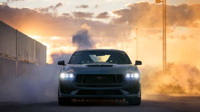 A Ford Mustang points at the camera, doing a burnout