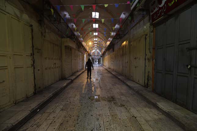 A Palestinian man walks down an empty street during a full strike in Nablus, West Bank.