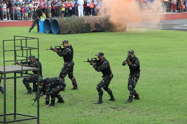 Soldiers practice an anti-terrorism drill using real weapons.