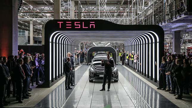 A photo of Elon Musk speaking at a Tesla plant.