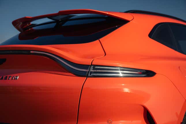 Taillight and rear spoiler of an orange 2025 Aston Martin DBX707