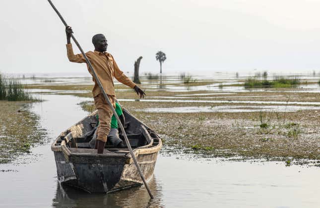 FILE - John Gafabusa, custodian of the Mutyona natural sacred site near Buliisa, Uganda, points at a water covered sacred site on Lake Albert at the Karakaba landing site, on Aug. 3, 2023. The French oil company TotalEnergies is failing to protect the sanctity of hundreds of graves in a controversial project that aims to build a heated pipeline from oil fields in Uganda to a port in Tanzania, according to a new report by a New York-based climate watchdog. (AP Photo/Hajarah Natwadda, File)