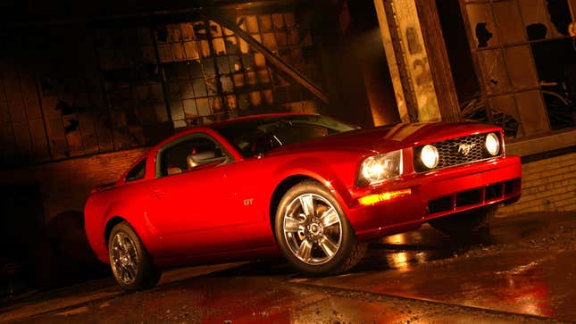 Front quarter view of a red Ford Mustang GT parked in a dimly lit warehouse