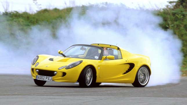 Un Lotus Elise amarillo deslizándose en una pista de carreras provocando una gran nube de humo de neumáticos