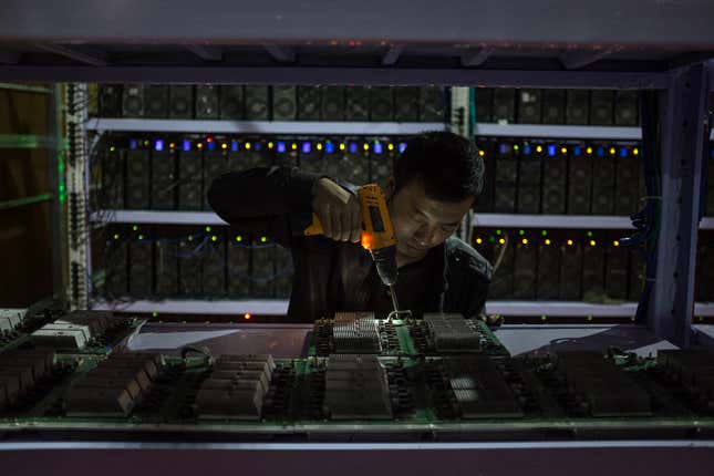 An employee reassembles a calculation board at a Bitcoin mine in Sichuan province.