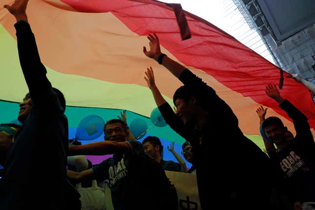 FILE - Participants raise a rainbow flag, a symbol of the gay rights movement during the annual Gay Pride Parade in Hong Kong on Nov. 25, 2017. A Hong Kong court on Tuesday, Oct. 24, 2023, upheld a ruling that favored the granting of equal inheritance rights to same-sex couples, in the latest victory for the city&#39;s LGBTQ+ community. (AP Photo/Vincent Yu, File)