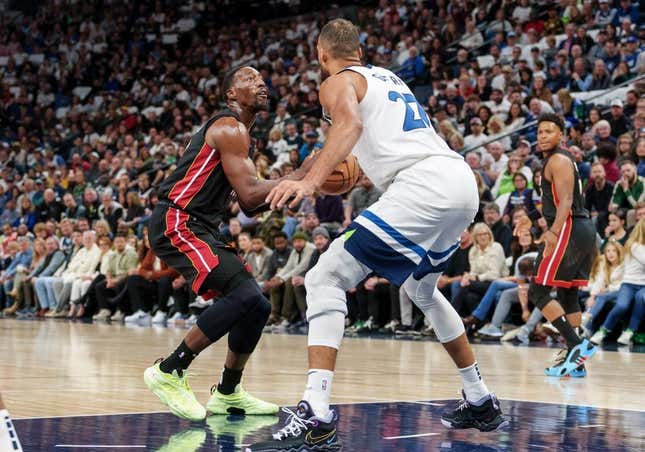 Oct 28, 2023; Minneapolis, Minnesota, USA; Miami Heat center Bam Adebayo (13) shoots the ball as Minnesota Timberwolves center Rudy Gobert (27) defends in the first quarter at Target Center.