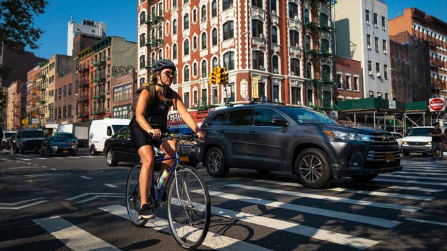 A photo of a person riding a bike through traffic. 