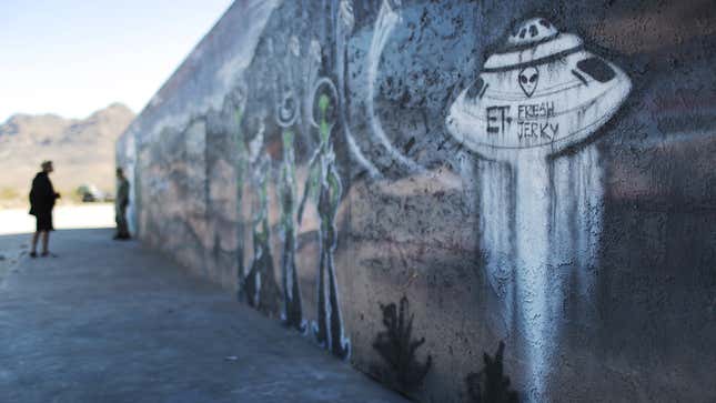 A photo of graffiti on a wall showing an alien spaceship. 