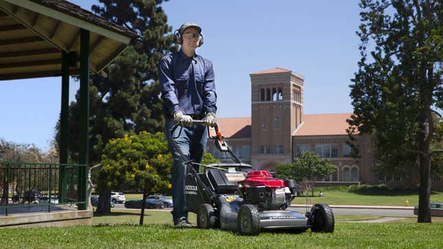 A photo of a man mowing a lawn with a Honda lawn mower 