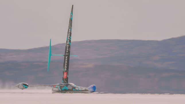 The black and teal-blue land yacht speeding across the lake bed.